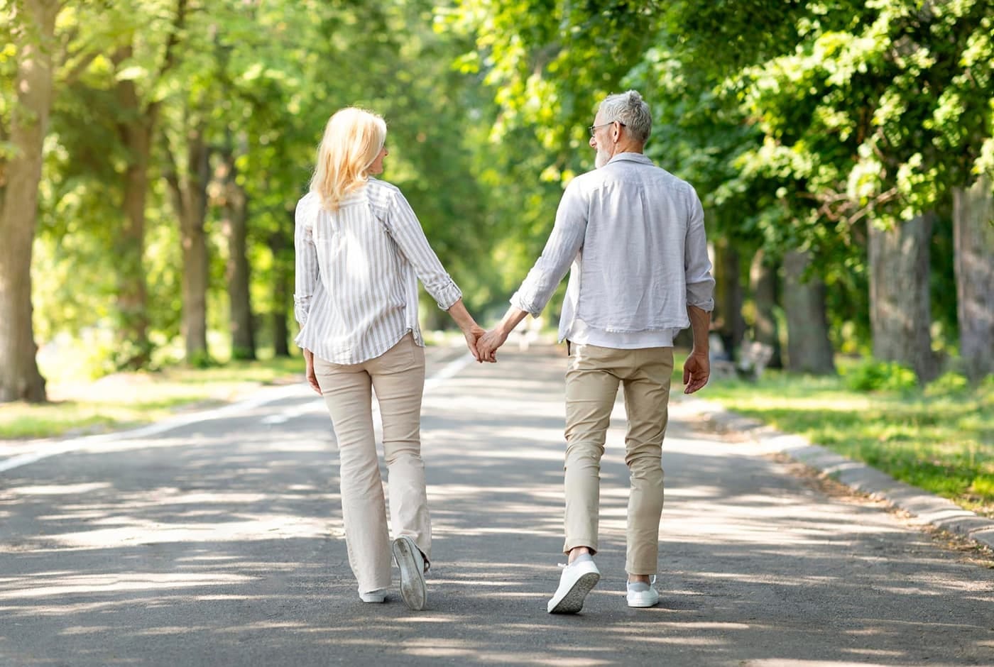 Older couple walking in the park holding hands