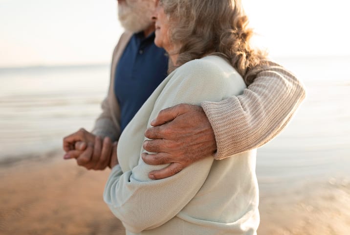 A couple walking on the beach at sunset