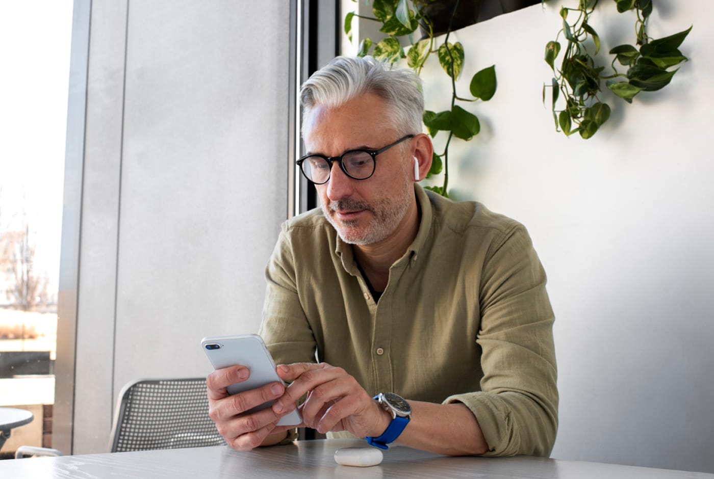 Mature man with glasses using a dating app on his phone